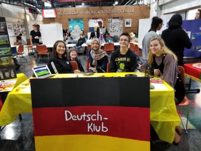 Students sit at a table with a German flag