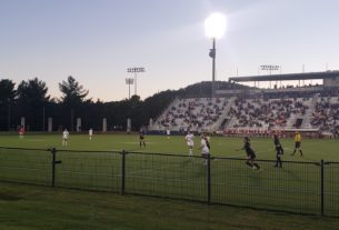 Members of the UVA Women's soccer team, clad in white jerseys, face off against the opposing Duke women's soccer team