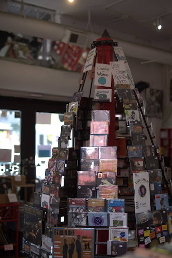 A display of CD's and records sits in the center of a music store.