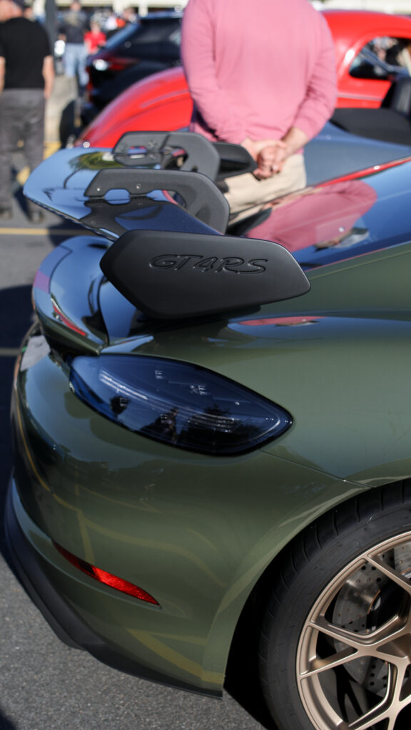 A green sports car in a parking lot.