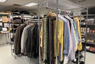 Various coats, dress shirts, ties, and pants sit on coat hanger racks in the Student Resource Center.