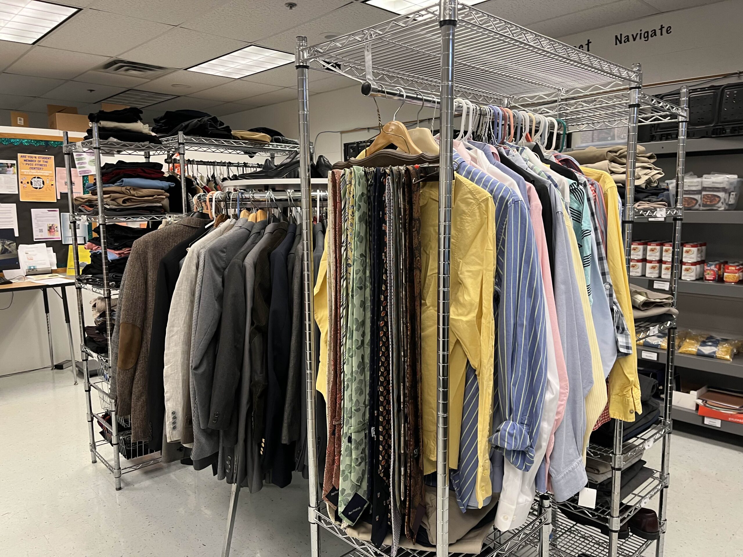 Various coats, dress shirts, ties, and pants sit on coat hanger racks in the Student Resource Center.