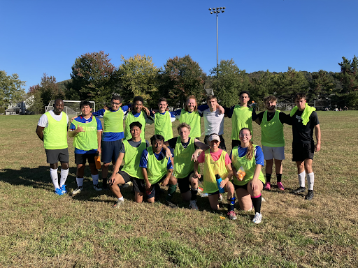 A group of PVCC students in neon green jerseys huddle up for a group photo.